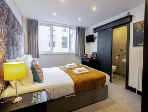 a bedroom with a large bed and a bathroom at Sinclair's Rooms in Southport