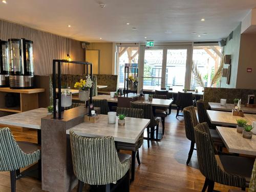 een eetkamer met tafels en stoelen en een restaurant bij Hotel de Pergola in Giethoorn