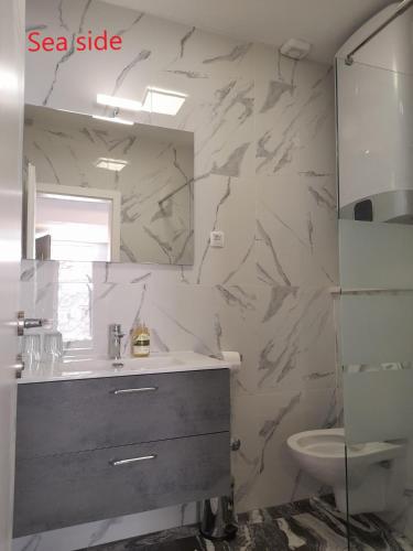 a bathroom with a sink and a toilet and a mirror at On the Beach Ivan Dolac in Ivan Dolac