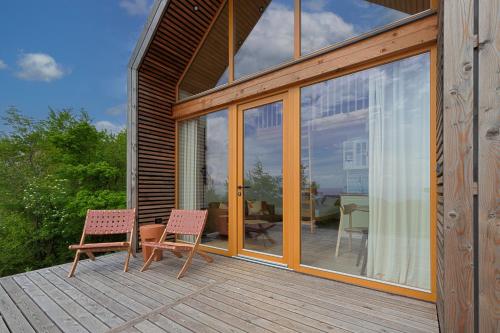 a wooden deck with two chairs and a table at Glamping Zarja, Vipava Valley in Zoll