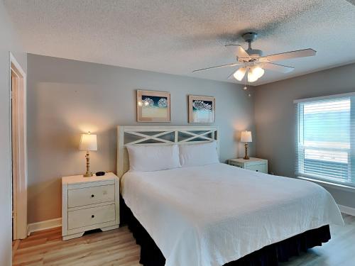 - une chambre avec un lit blanc et un ventilateur de plafond dans l'établissement Sea Oats #409, à Fort Walton Beach