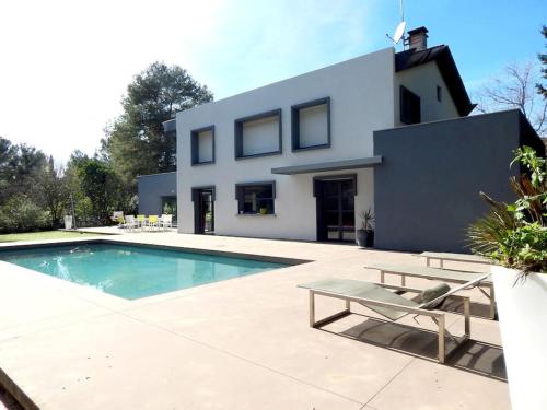 une maison avec une piscine devant une maison dans l'établissement Villa contemporaine proche de Montpellier, à Castelnau-le-Lez