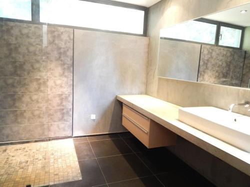 une salle de bain avec un lavabo et un miroir dans l'établissement Villa contemporaine proche de Montpellier, à Castelnau-le-Lez