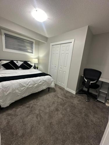 a bedroom with a bed and a desk and a chair at Luxurious Home in NW Calgary, Free Parking, High Speed Internet, Near Grocery and Airport in Calgary