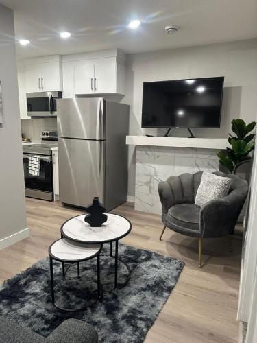 a kitchen with a refrigerator and a chair and a table at Luxurious Home in NW Calgary, Free Parking, High Speed Internet, Near Grocery and Airport in Calgary