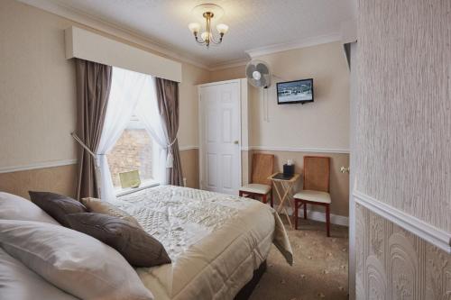 1 dormitorio con cama y ventana en The Shrewsbury Guest House, en Great Yarmouth