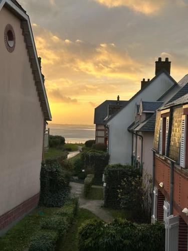 a group of houses with the ocean in the background at Maison vue baie rénovée 8 couchages in Le Crotoy