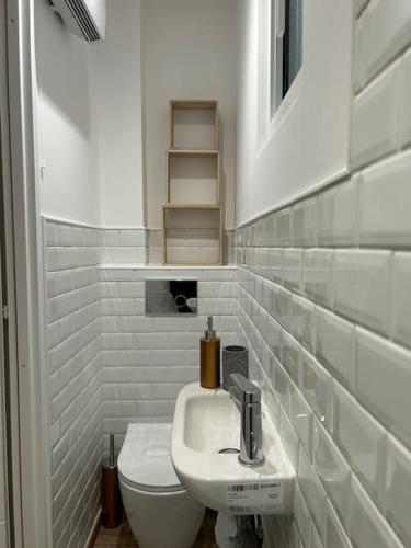a white bathroom with a toilet and a sink at Maison vue baie rénovée 8 couchages in Le Crotoy