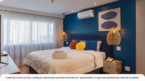 1 dormitorio con paredes azules y 1 cama con almohadas coloridas en Cyclinn Berrini, en São Paulo