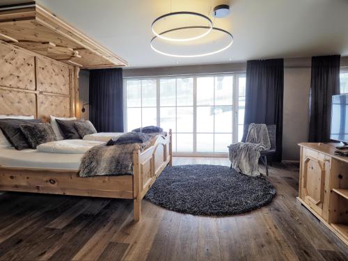 a bedroom with a large bed and a large window at Wellness & Naturresort Reischlhof in Wegscheid