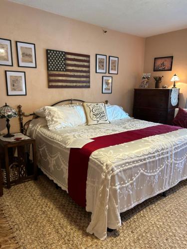 Ms. Maggie's South Country Inn في دايتونا بيتش: غرفة نوم مع سرير مع علم أمريكي على الحائط