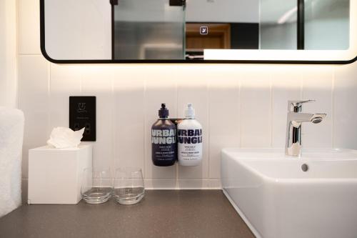 YOTELPAD London Stratford في لندن: منضدة الحمام مع الحوض والمرآة
