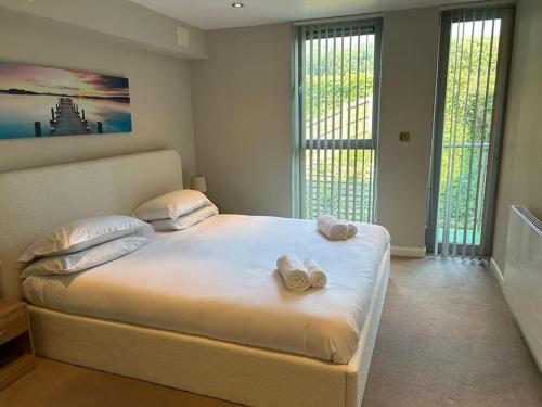 ニューキーにあるModern apartment, Fistral beachのタオルが敷かれた大きなベッドのある寝室
