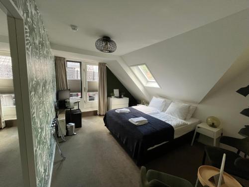 een slaapkamer met een bed op zolder bij Hotel de Pergola in Giethoorn