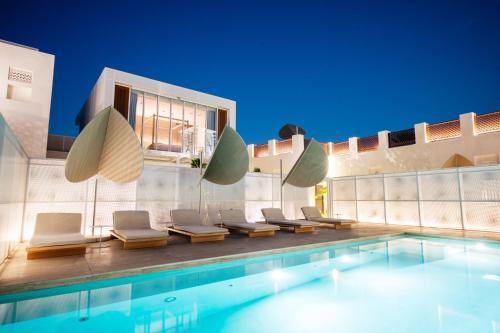 una piscina con tumbonas y una casa en The Chedi Al Bait, Sharjah en Sharjah