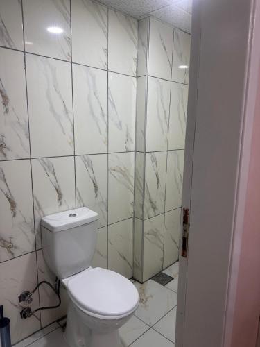 a bathroom with a white toilet and marble tiles at Asya Hotel in Konya