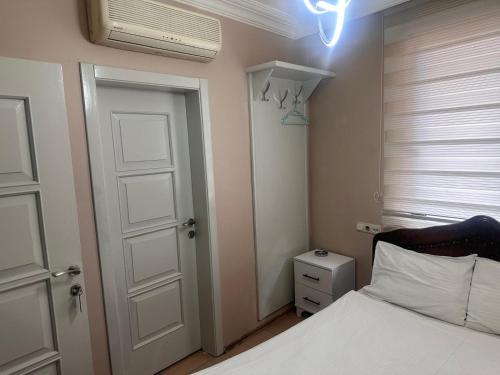 a bedroom with a white bed and a white door at Asya Hotel in Konya
