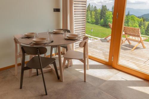a table and chairs in a room with a balcony at Glamping Zarja, Vipava Valley in Zoll