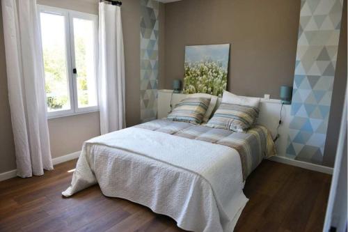 a bedroom with a bed and a window at Villa au calme et sans vis à vis , proche du village in La Bastide-des-Jourdans
