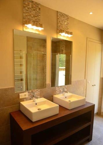 une salle de bain avec deux lavabos et un grand miroir dans l'établissement Villa au calme et sans vis à vis , proche du village, à La Bastide-des-Jourdans