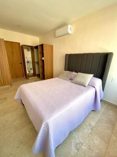 a bedroom with a large white bed with purple sheets at Dept Nuevo 4pers- Alberca- 3 cdr Playa in Boca del Río