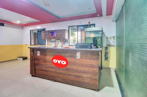 un restaurante con un mostrador con un cartel en Hotel O Vinit Lodging, en Nagpur