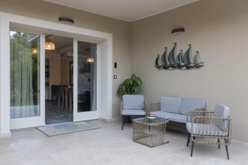 a living room with a couch and chairs at BnB Il Grecale in Lacona