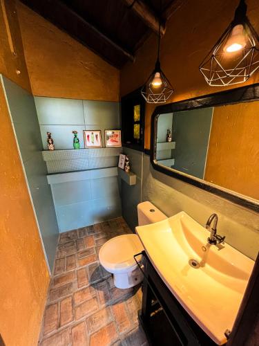 a bathroom with a sink and a toilet at Namaste Flats Praia do Rosa in Imbituba