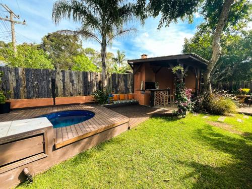 a backyard with a swimming pool and a house at Namaste Flats Praia do Rosa in Imbituba