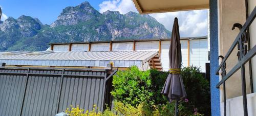 una sombrilla frente a un edificio con una montaña en Appartamenti Scilla e Lavinia, en Riva del Garda