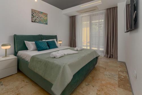 a bedroom with a large bed with towels on it at Astria Eclipse - Complex Novum in Olimp
