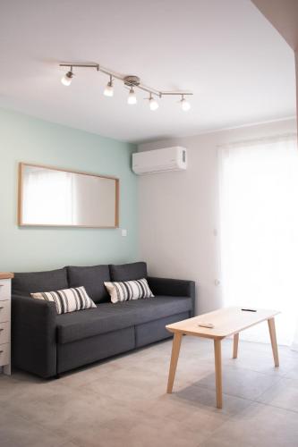 a living room with a black couch and a table at Belair #Chalkidiki Lux App - Gerakini in Patelidhás