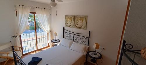 1 dormitorio con cama y ventana grande en Apartamento La Marina - VVMU057, en Bolnuevo