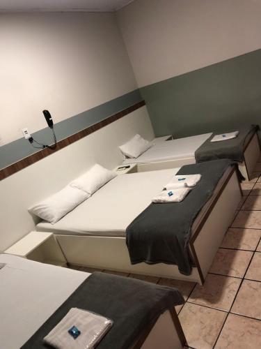 two twin beds in a room with at Hotel Sany SP- Metrô Paulista in Sao Paulo