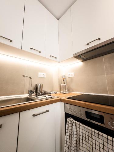 a kitchen with white cabinets and a sink at Belair #Chalkidiki Lux App - Gerakini in Patelidhás