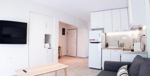 a living room with a couch and a kitchen at Belair #Chalkidiki Lux App - Gerakini in Patelidhás