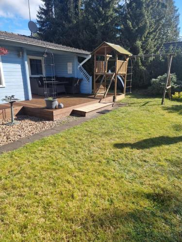 a backyard with a wooden deck and a swing at Zur Meise in Winsen Aller