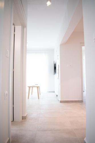 an empty hallway with a table in the middle of a room at Belair #Chalkidiki Lux App - Gerakini in Patelidhás