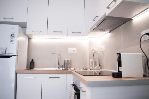 a kitchen with white cabinets and a sink at Belair #Chalkidiki Lux App - Gerakini in Patelidhás