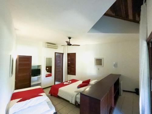 a bedroom with two beds and a ceiling fan at Brasil Tropical Village in Pipa