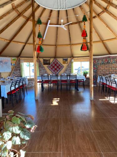 a dining room with tables and chairs in a tent at Yurt camp Sonun in Bokonbayevo