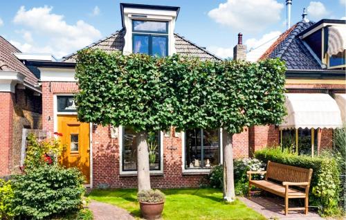 スネークにあるLovely Home In Sneek With Wifiの前庭に木のあるレンガ造りの家
