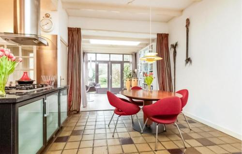 スネークにあるLovely Home In Sneek With Wifiのキッチン(木製テーブル、赤い椅子付)