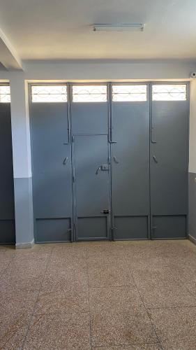 una fila de cuatro puertas metálicas en una habitación en Big appartement in ksar sgher and close, en Alcazarseguir