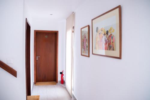 a hallway with two pictures on the wall and a door at La Varangue in Antananarivo