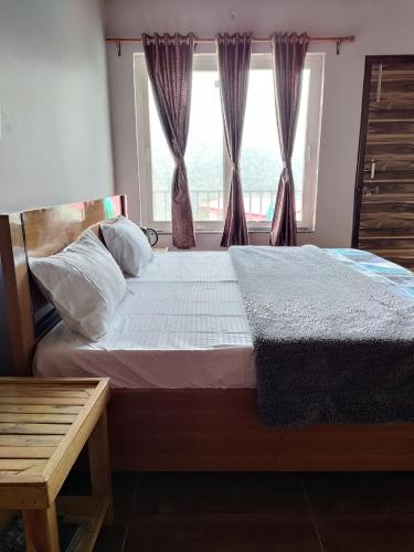 a bedroom with a large bed with a window at The Dhaila's Nest Inn in Rāmgarh