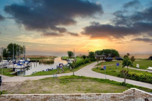 a sunset over a marina with boats in the water at Wasserblick Loddin Deluxe 8 in Loddin