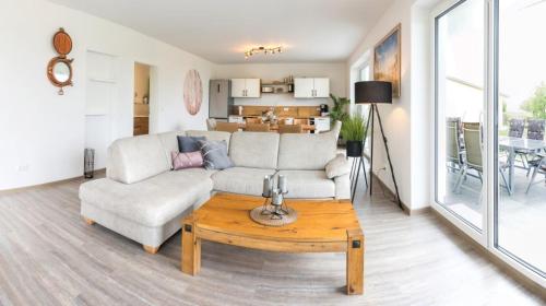a living room with a couch and a table at Wasserblick Loddin Deluxe 8 in Loddin