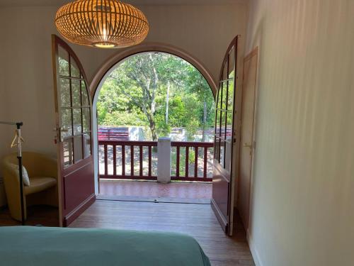 - une chambre avec une porte ouverte sur un balcon dans l'établissement Belle villa basque familiale, à Arcachon