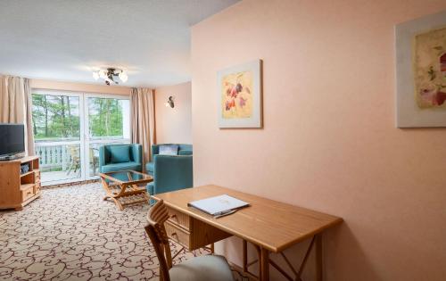 uma sala de estar com uma secretária e uma mesa em Panorama Seeresort & Spa em Warnitz